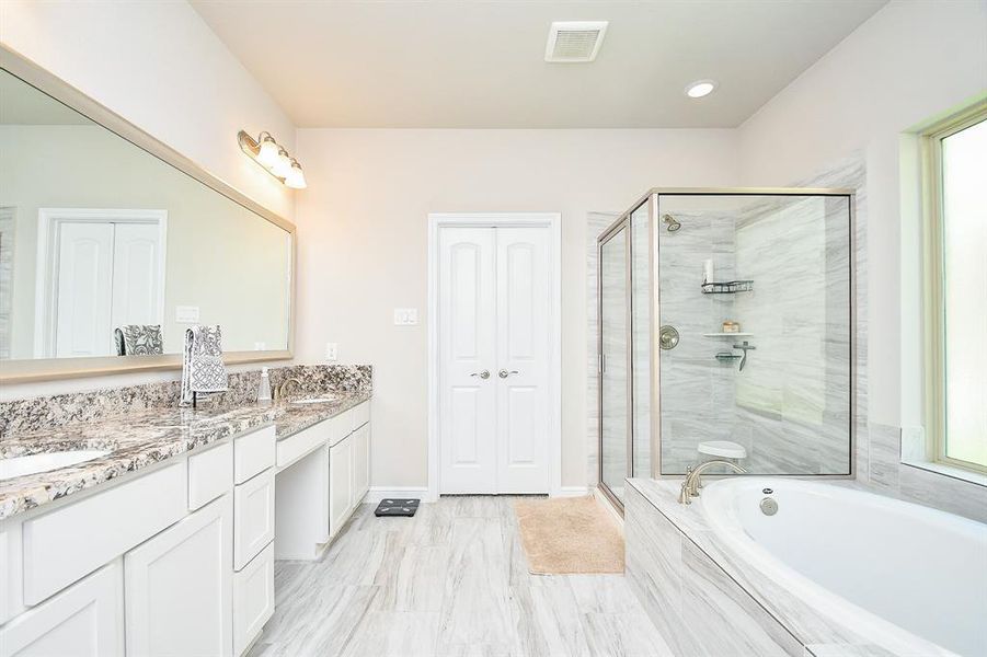 Primary bath -double sinks and a sit down vanity.