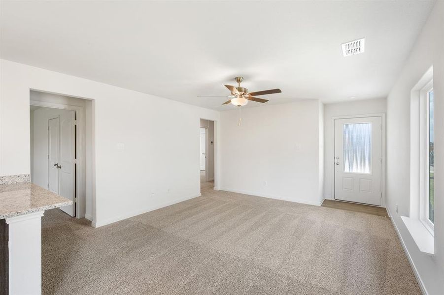 Carpeted living room featuring ceiling fan