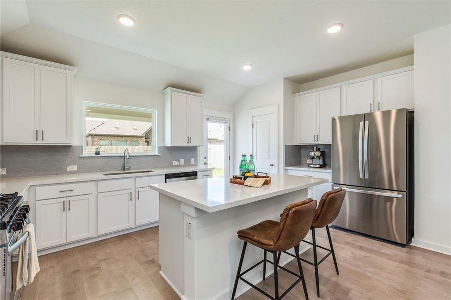 Stainless steel appliances and quartz countertops add a modern touch to this spacious kitchen overlooking your backyard.