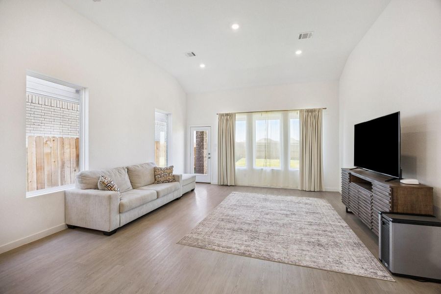 Spacious family room with high ceilings and an array of windows that allow natural light to overflow into the home.