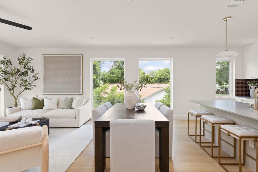 Natural light pours through large windows into this airy, open-concept living and dining area. Natural light pours through large windows into this airy, open-concept living and dining area.