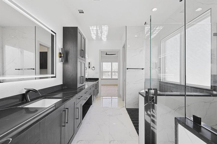 Bathroom with ceiling fan with notable chandelier, vanity, and an enclosed shower