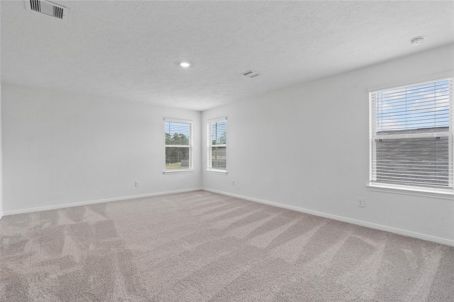 Relax and recharge in this stunning primary suite! This expansive room offers plush carpeting, neutral custom paint, high ceilings, recessed lighting and large windows fitted with privacy blinds—perfect for unwinding after a long day.