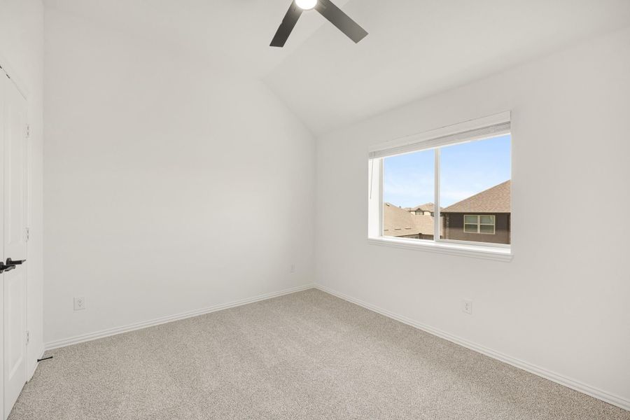 Empty bedroom with vaulted ceiling, ceiling fan, carpet flooring, and single window