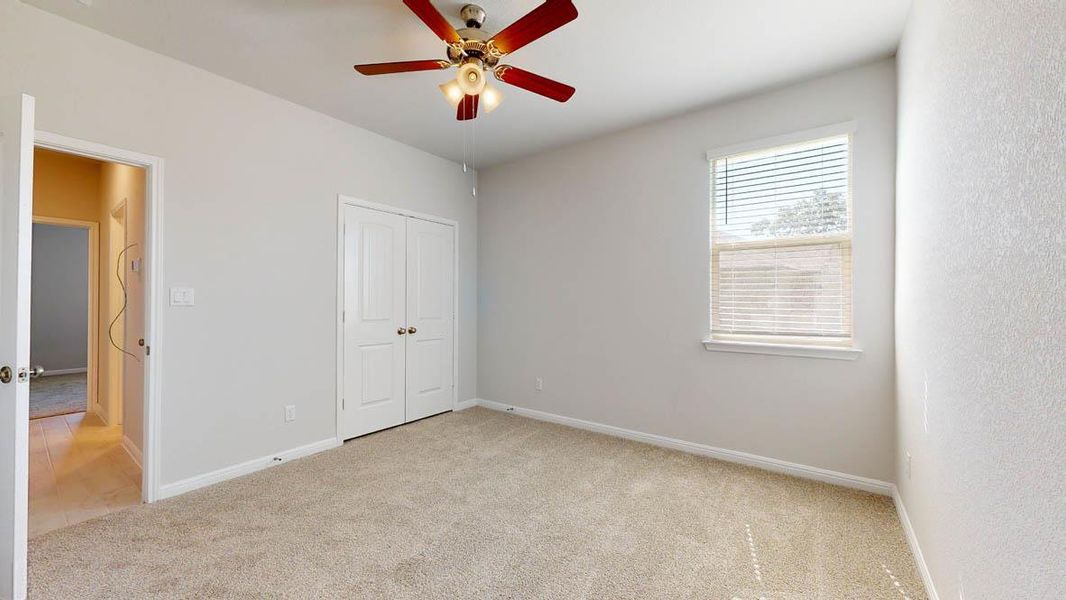 Unfurnished bedroom with light carpet, a closet, and a ceiling fan