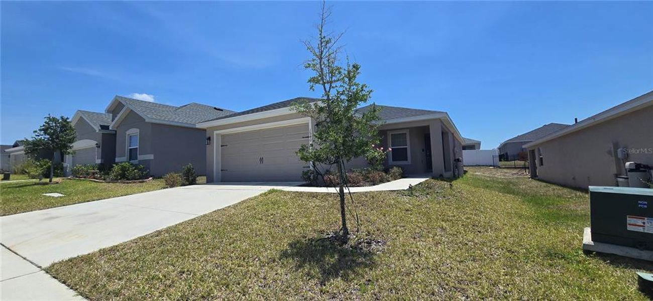 Front exterior of a new home in Geneva Landings, Davenport, FL, highlighting curb appeal (Image 12).