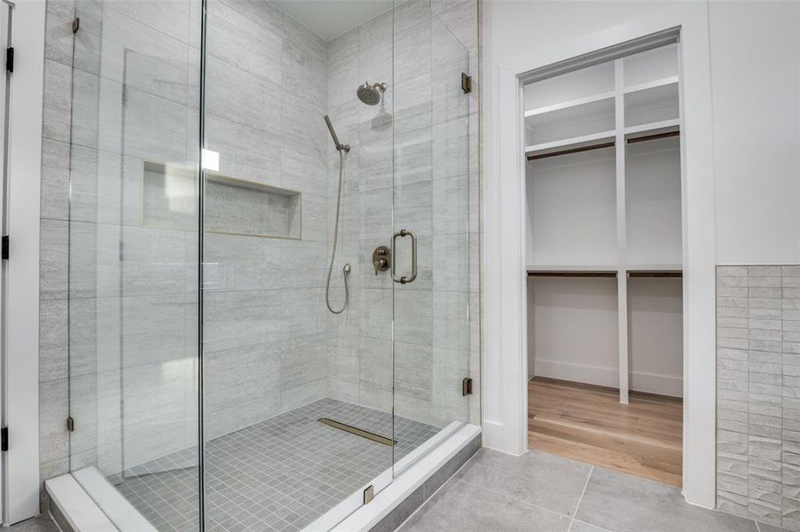 Bathroom with a shower stall, a spacious closet, and tile patterned floors Bathroom with a shower stall, a spacious closet, and tile patterned floors