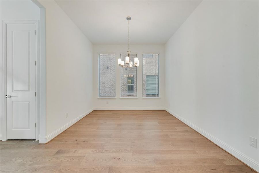 Unfurnished dining area with light hardwood / wood-style flooring and a chandelier