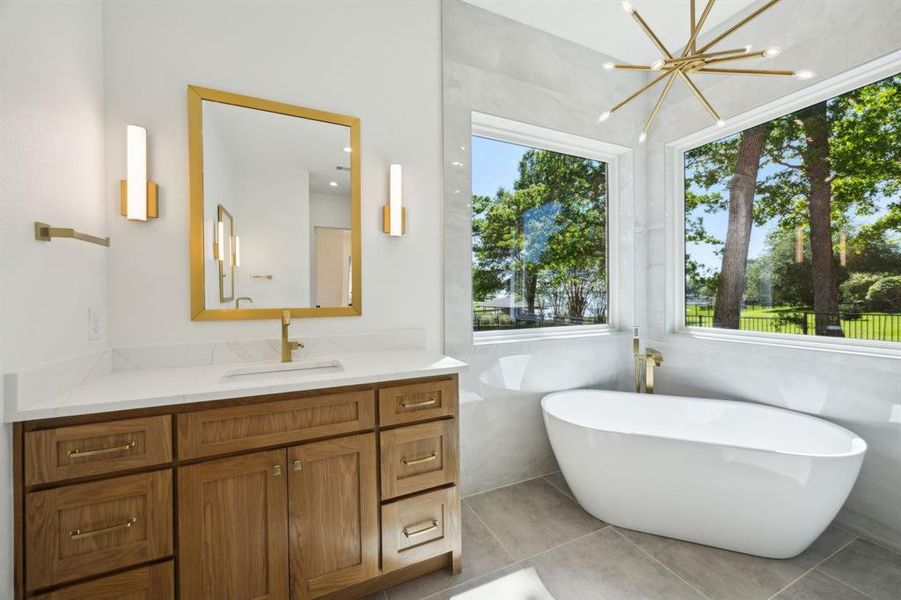 Primary Bathroom with a freestanding bath, tile patterned flooring, vanity, and a chandelier Primary Bathroom with a freestanding bath, tile patterned flooring, vanity, and a chandelier