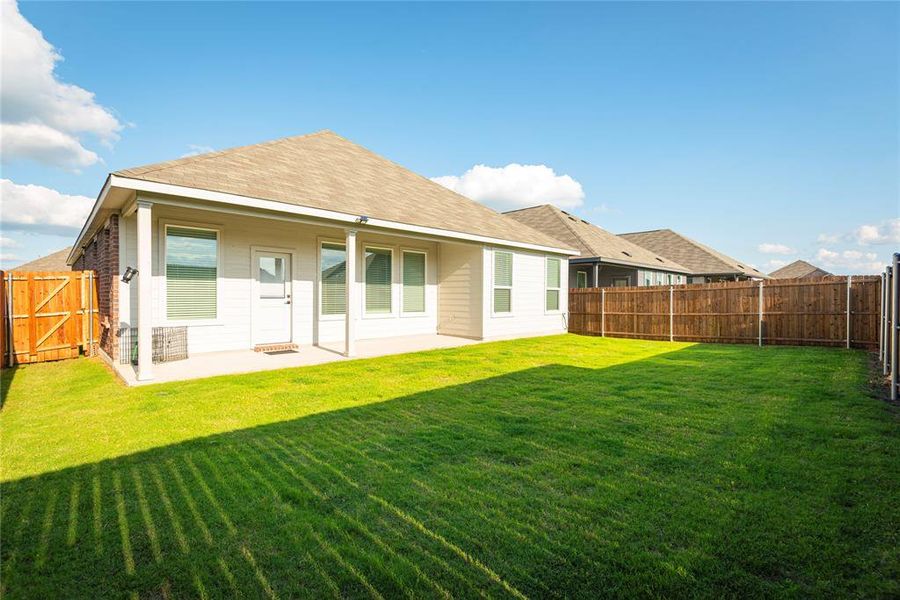 Expansive green lawn bordering a concrete patio with a covered porch Expansive green lawn bordering a concrete patio with a covered porch