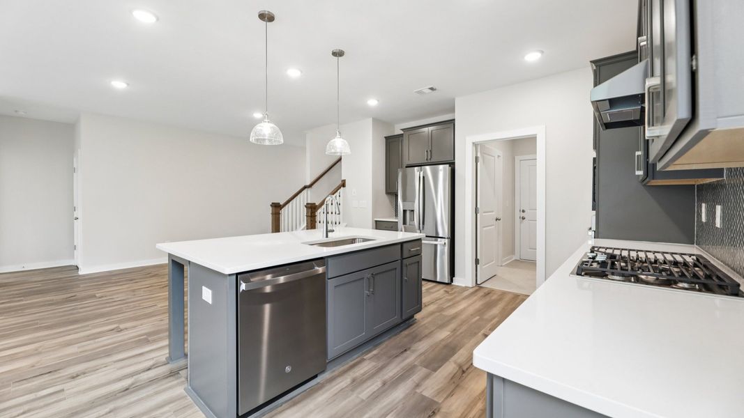 Kitchen with hard surface flooring, quartz countertops, and pendant lighting Kitchen with hard surface flooring, quartz countertops, and pendant lighting