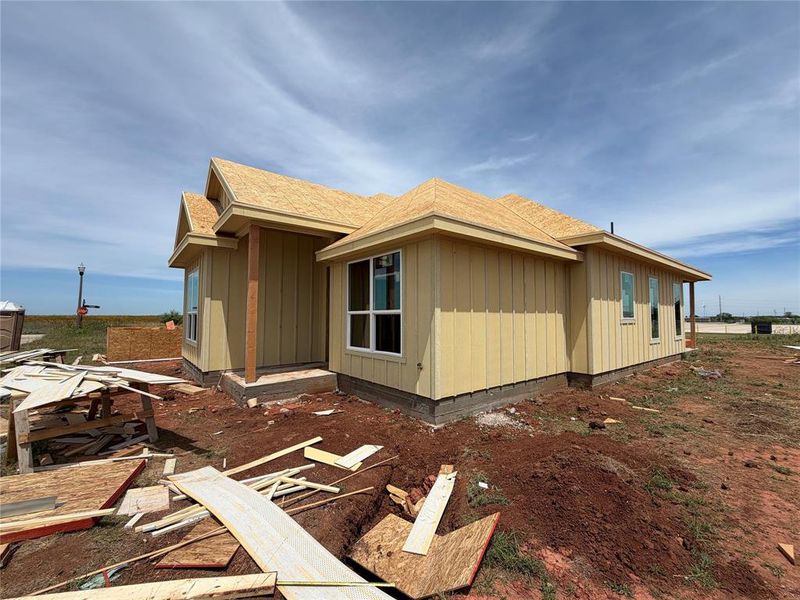 Single-story residence featuring board and batten siding and multiple white-framed windows