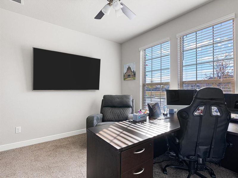 Home office with carpet flooring and ceiling fan