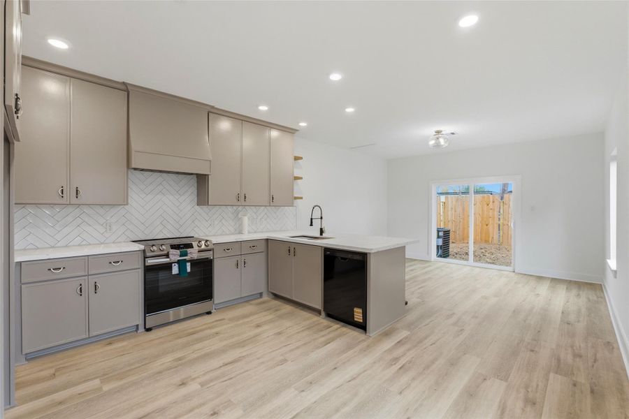 Custom, solid wood cabinets, neutral finishes, gold & black hardware, stainless steel appliances, exposed shelving, and plenty of natural light. What more could you ask for in your dream kitchen?!