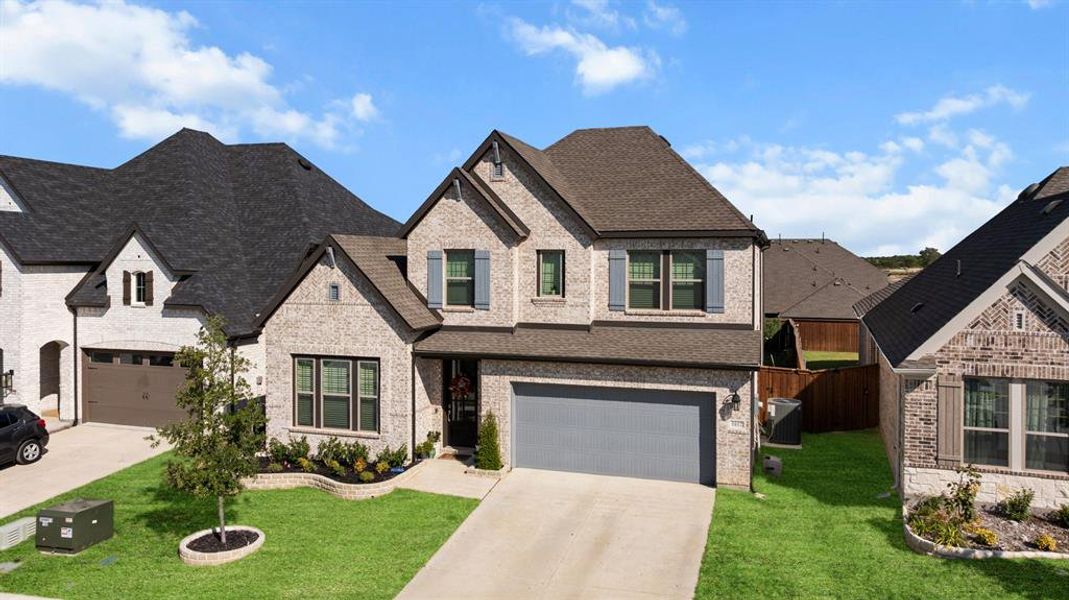 French country home with brick siding, driveway, and a garage French country home with brick siding, driveway, and a garage