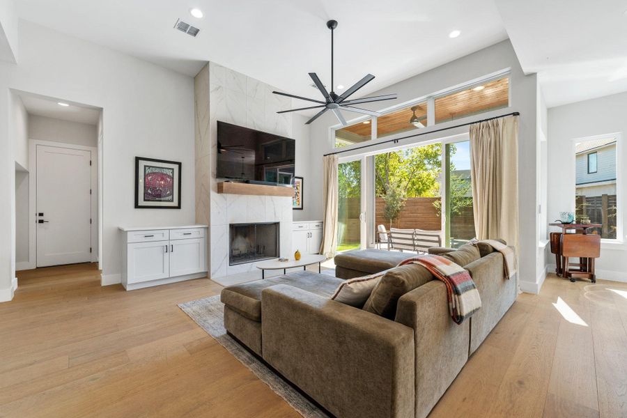 Living area featuring a high end fireplace, light wood-style floors, recessed lighting, and a ceiling fan