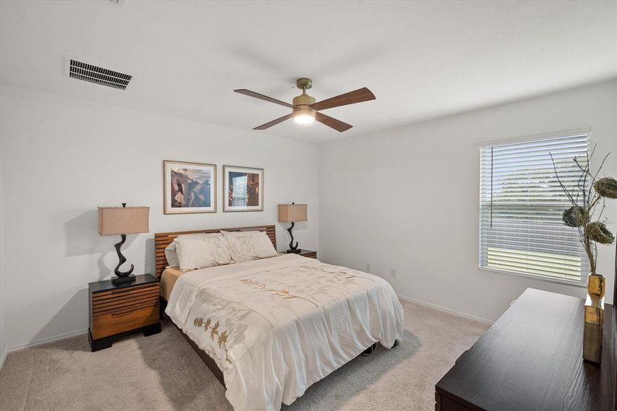 Carpeted bedroom featuring a ceiling fan and baseboards