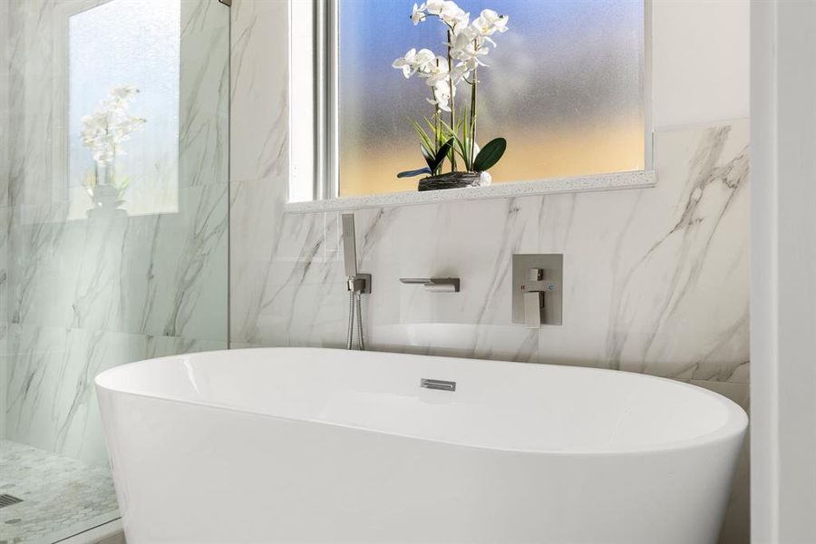 Bathroom with a tub and tile walls