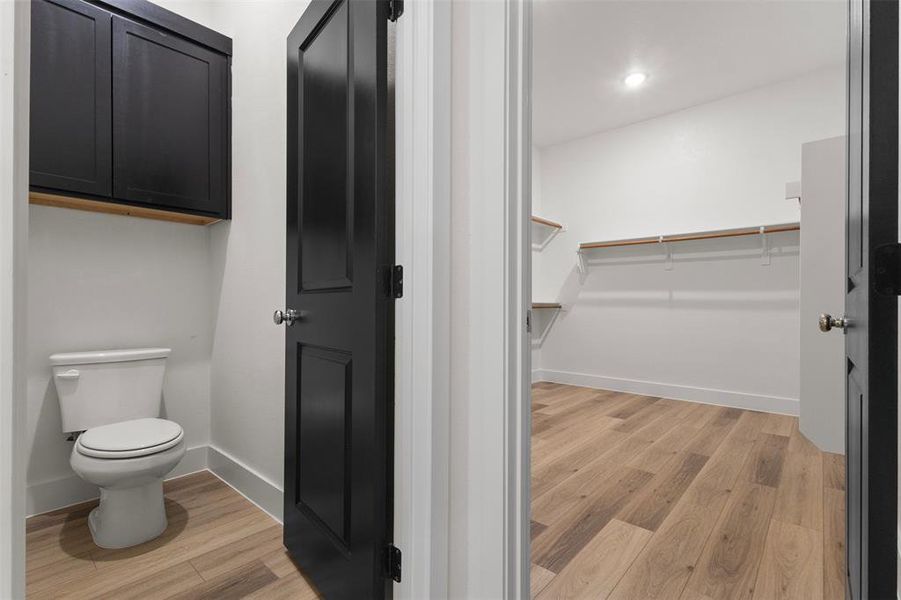 Bathroom featuring light wood-type flooring, a spacious closet, and recessed lighting