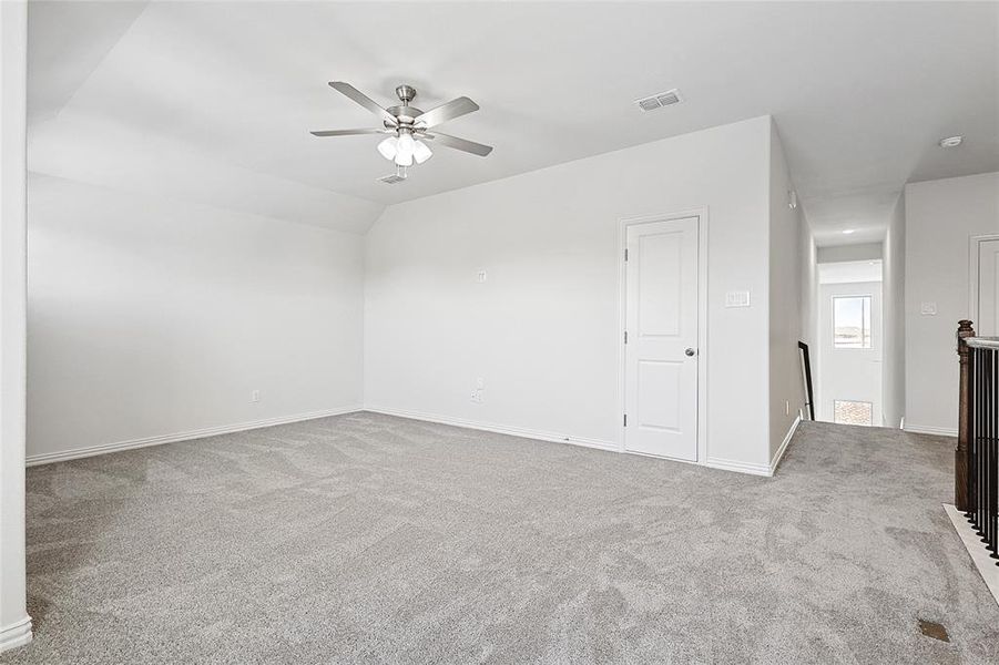 Spare room with light colored carpet, a ceiling fan, and vaulted ceiling Spare room with light colored carpet, a ceiling fan, and vaulted ceiling