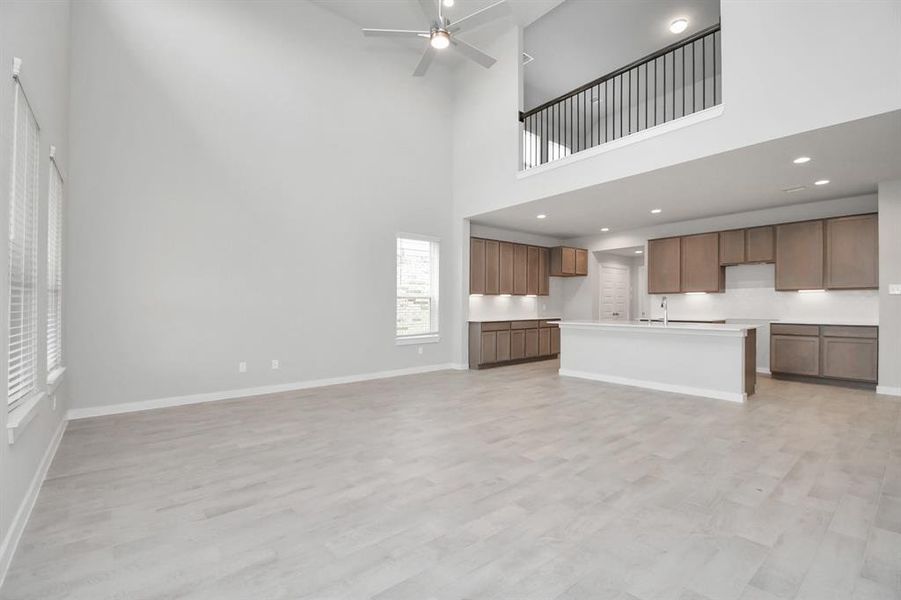 Welcome family and guests to your charming living room! With its high ceilings, recessed lighting, ceiling fan, custom paint, beautiful flooring, and large windows that let in abundant natural light, this room is perfect for gatherings.