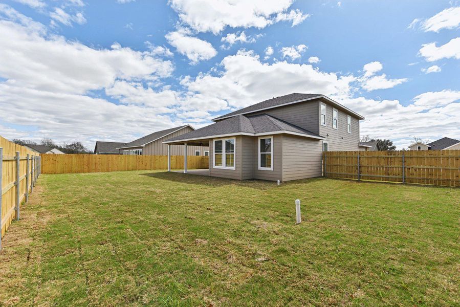 Back of property featuring a yard and a fenced backyard Back of property featuring a yard and a fenced backyard