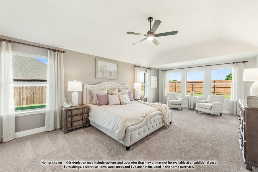 Spacious master bedroom with vaulted ceiling, ceiling fan, carpet flooring, and multiple windows