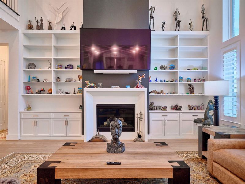 The primary living area boasts a stunning floor-to-ceiling Madir cast fireplace, accented by custom cabinetry.
