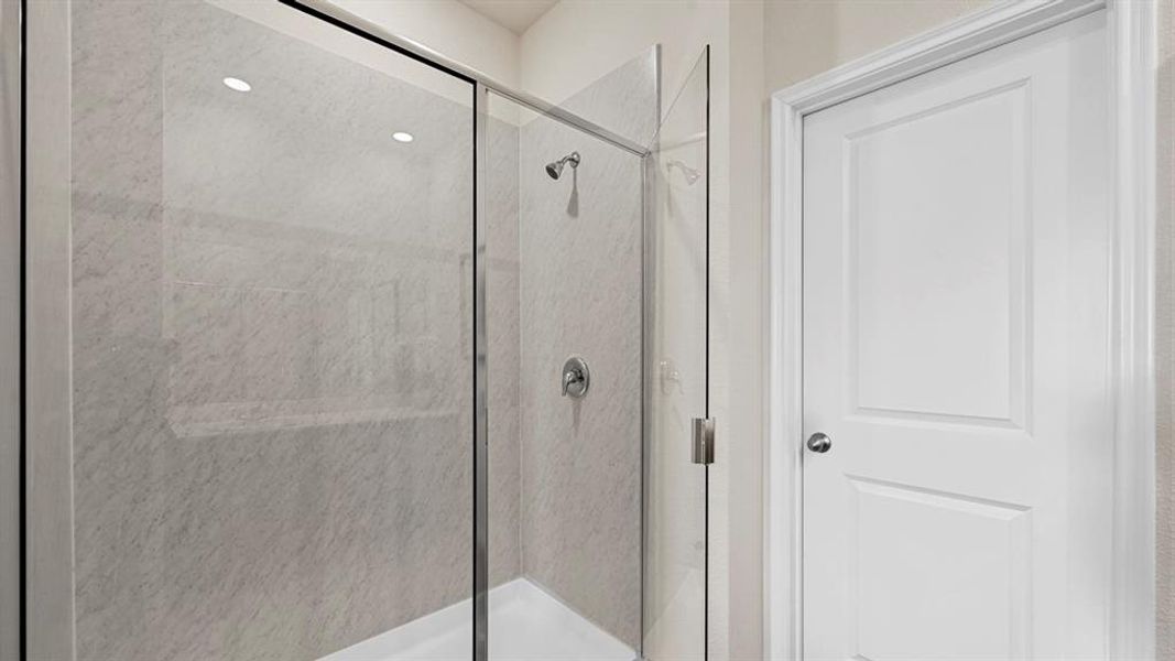 The bathroom features a shower with glass enclosure and a white paneled door The bathroom features a shower with glass enclosure and a white paneled door