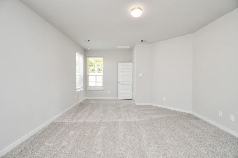 Come and unwind after a long day in this magnificent primary suite! This spacious room features plush carpet, warm paint, high ceilings and large windows with privacy blinds. Sample photo of completed home with similar floor plan. Actual colors and selections may vary.