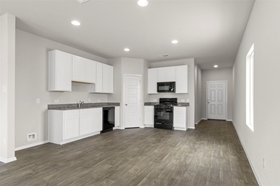 Kitchen featuring black appliances, dark wood-style flooring, white cabinetry, and recessed lighting Kitchen featuring black appliances, dark wood-style flooring, white cabinetry, and recessed lighting