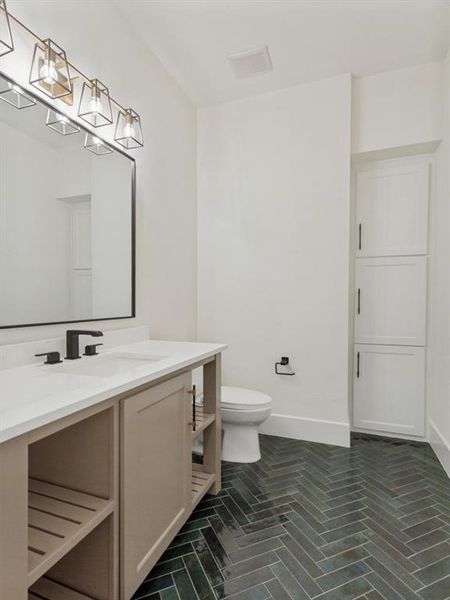 Bathroom featuring a single vanity with a light countertop, black fixtures, and a rectangular mirror Bathroom featuring a single vanity with a light countertop, black fixtures, and a rectangular mirror