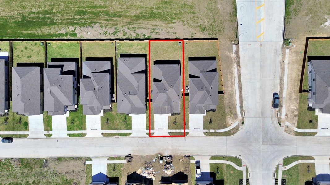 An aerial view of a spacious subdivision lot, highlighting a well-maintained yard and a fully fenced perimeter, offering both privacy and expansive outdoor space.
