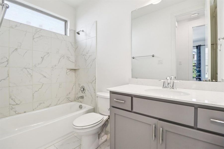 Bathroom with shower / washtub combination, vanity, and light marble finish floors Bathroom with shower / washtub combination, vanity, and light marble finish floors