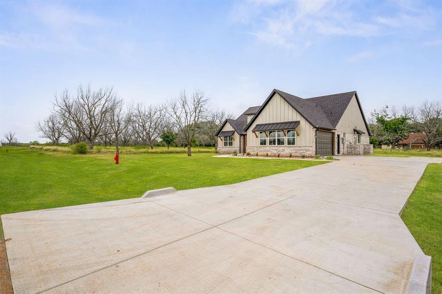 View of front of house featuring a garage and a front lawn