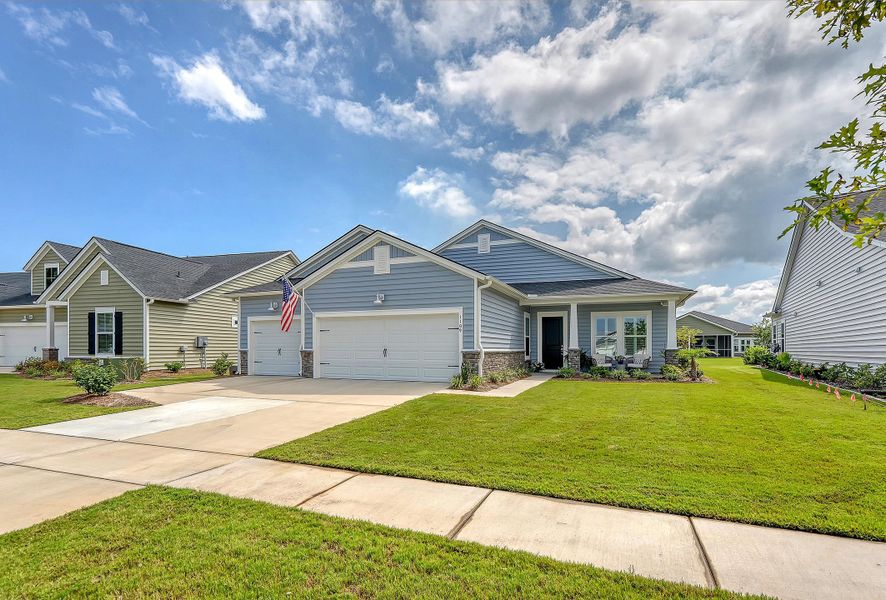 Front exterior of a new home in Horizons at Summers Corner | 55+: The Estates, Summerville, SC, highlighting curb appeal (Image 21).