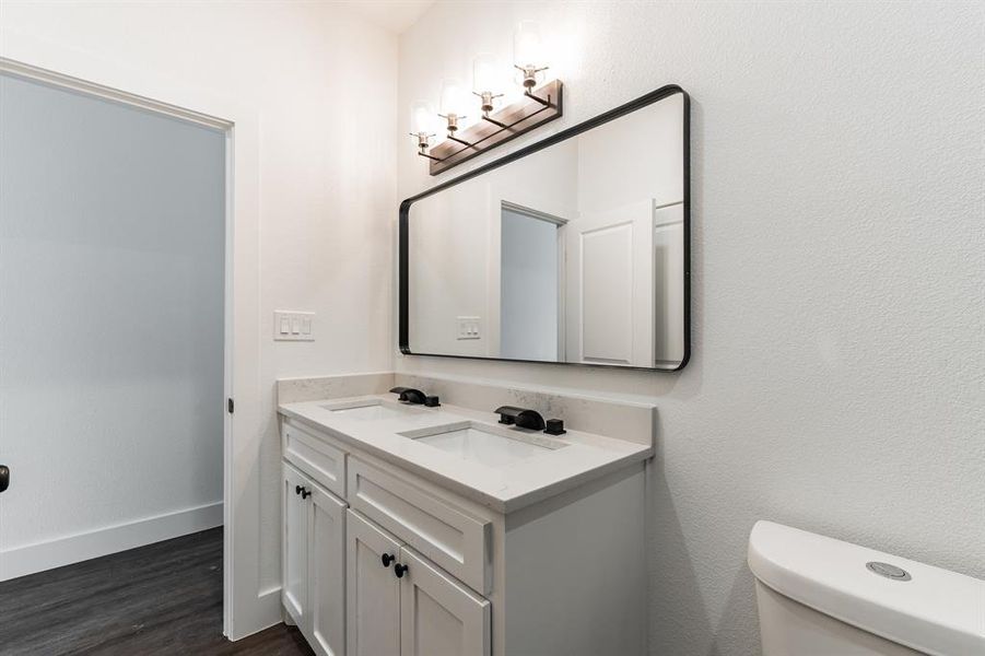 Bathroom featuring vanity, hardwood / wood-style floors, and toilet