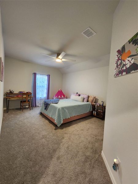 A comfortable bedroom features plush carpet and an inviting ceiling fan for year-round comfort.