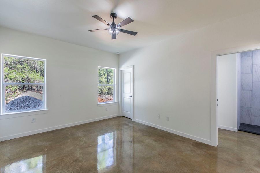 Spare room featuring concrete floors and ceiling fan