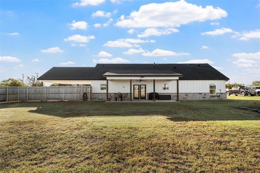 Back of property featuring french doors, a patio, a shingled roof, and board and batten siding