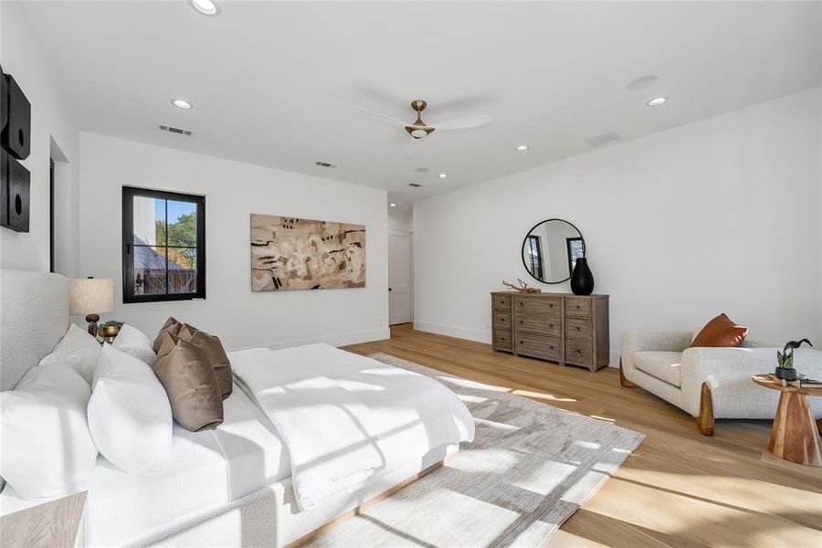 Spacious room featuring light wood-finish flooring, recessed lighting, and a ceiling fan