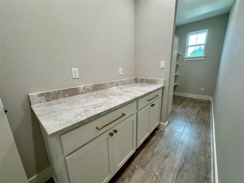 Bathroom with wood finished floors, a textured wall, vanity, and baseboards Bathroom with wood finished floors, a textured wall, vanity, and baseboards