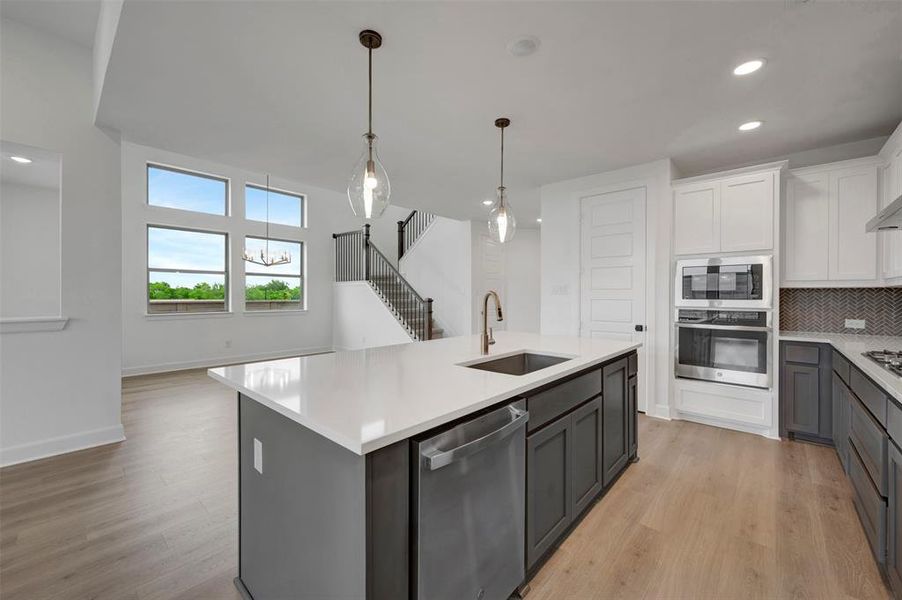 The property features a bright kitchen with an island, stone countertops, and stainless steel appliances