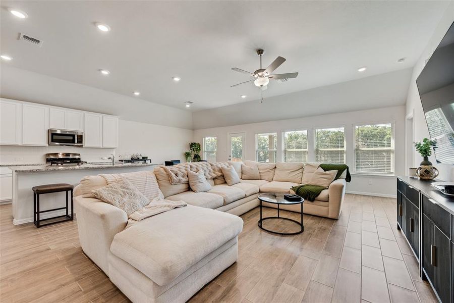 Living area featuring recessed lighting, wood finish floors, a ceiling fan, and vaulted ceiling Living area featuring recessed lighting, wood finish floors, a ceiling fan, and vaulted ceiling