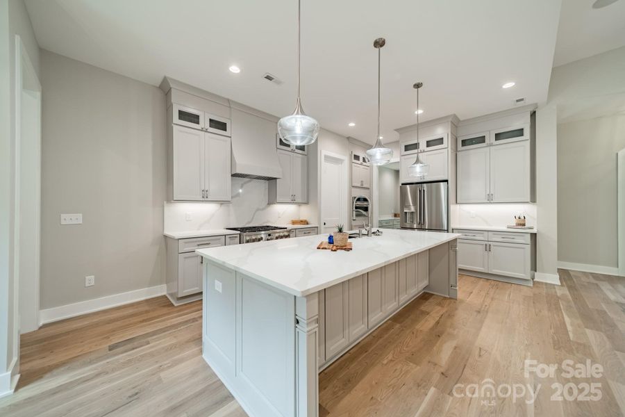 Fabulous Chef's Kitchen with oversized Gas Range and Oven, Quartz Counter Tops and Backsplash, and Custom Cabinetry