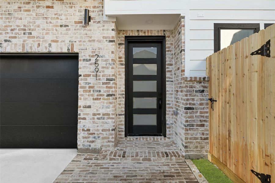 Front door, brick and private two car garage