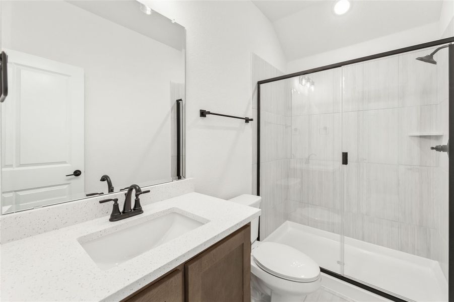 Bathroom with quartz vanity, dark bronze fixtures, and glass-enclosed tiled shower-tub combo Bathroom with quartz vanity, dark bronze fixtures, and glass-enclosed tiled shower-tub combo