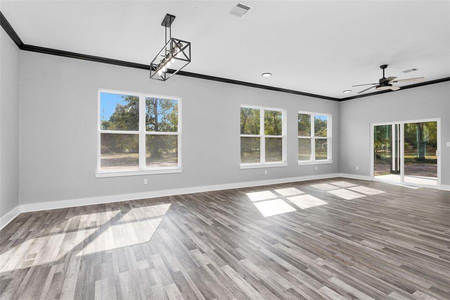 This is a view of dining and living room from the kitchen with a wall of windows so you can enjoy the view all day long. This is the perfect home for family time and entertaining.