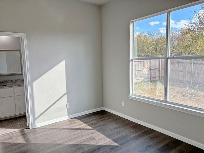 Empty room featuring dark wood finished floors and baseboards