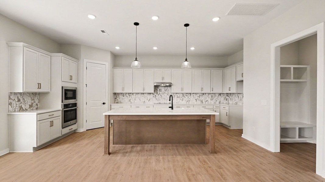 Huge kitchen with quartz countertops and accent backsplash, with a corner pantry and tons of workspace